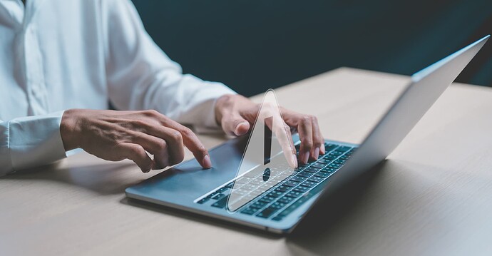 Person typing on a laptop with a 3D warning triangle imposed over the keyboard