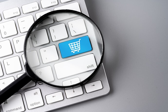 Magnify glass on a keyboard, with the enter key replaced by a blue key with a shopping trolley icon